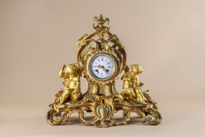 a gold clock sitting on top of a table