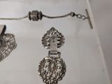 a silver necklace and a pair of shoes on a table