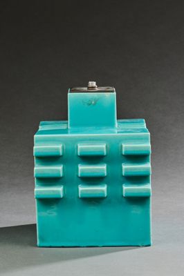 un vase bleu surmonté d'un petit bâtiment