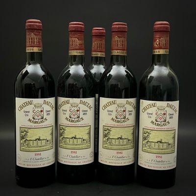 quatre bouteilles de vin rouge sont alignées sur une surface noire