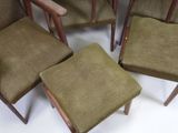 four chairs with green upholstered cushions sit in a circle