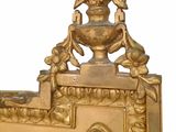 a gold mirror with a bird on top of it
