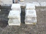 two stone benches sitting next to each other on the ground