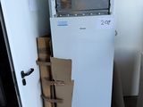 a white refrigerator and a stack of boxes in a room