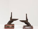 paire de sculptures en bronze représentant des oiseaux, posées sur des blocs de marbre, sur un fond blanc