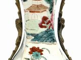 a vase with a painting on it sitting on a table