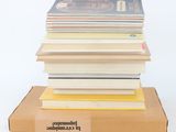 a stack of books sitting on top of a cardboard box