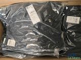 a cardboard box with a bunch of black shirts in it