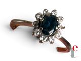 an image of a ring with a blue stone surrounded by white diamonds