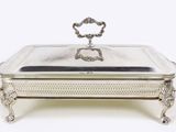 a silver plate with a handle on top of it on a stand