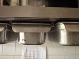 three stainless steel sinks in a kitchen with a paper towel on the counter