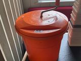un grand seau orange posé sur une étagère près d'une fenêtre