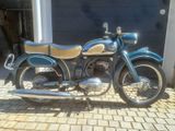 une moto bleue garée devant un garage
