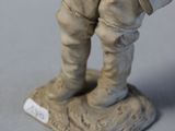 figurine of a man in a suit and tie holding a bag