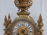 a gold clock that is sitting on top of a table