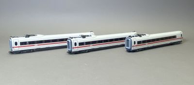 deux trains miniatures posés côte à côte sur une surface grise