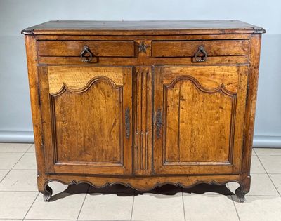 une vieille armoire en bois posée sur un sol carrelé