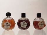 three small bottles of different flavored syrup sitting on a table