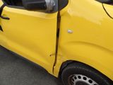 a small yellow car with a broken door and a broken window