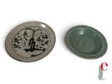 two plates with designs on them sitting next to each other