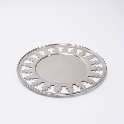 une plaque d'argent ornée d'un motif sur une surface blanche