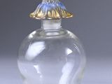 a small glass jar with a gold lid on a white surface