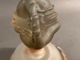 a glass sculpture of a man with a hat on top of it