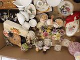 a cardboard box filled with assorted items including tea cups and saucers