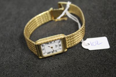 an image of a gold wrist watch with a price tag on it