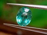 une image montrant un gros plan d'un diamant bleu tenu par une pince