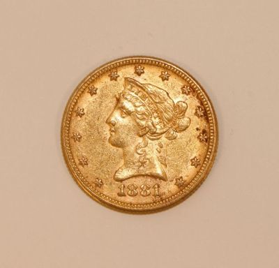 a close up of a gold coin with a woman ' s head on it