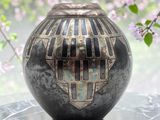 a vase that is sitting on a table with flowers in the background