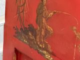a red cabinet with a painting of a man fishing on it