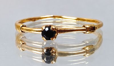 an image of a close up of a gold ring with a black stone