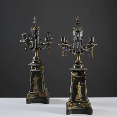 une paire de chandeliers noirs et dorés ornés de figures