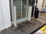 une porte coulissante en verre dans un magasin, avec une pancarte posée au sol