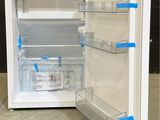 a white refrigerator with blue tape on the door
