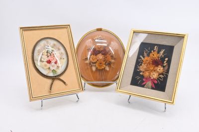 trois photos de fleurs encadrées sont exposées dans une vitrine