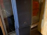 a black speaker that is sitting in front of a refrigerator