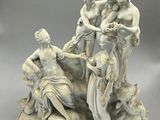an image of a statue of a group of women on a rock
