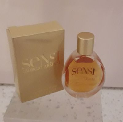 un flacon de parfum posé sur une table à côté d'une boîte