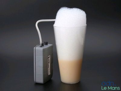 une boisson mousseuse dans un gobelet en plastique, à côté d'un briquet