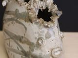 a white vase with a hole in it sitting on a table