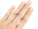 purple amethorate and diamond ring on a woman ' s hand