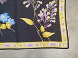 a black and yellow scarf with blue flowers on it