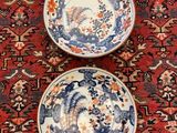 two bowls sitting on a red rug on the floor