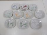 several plates with drawings of animals on them on a white surface