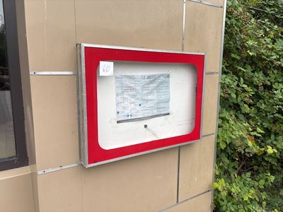 un panneau rouge et blanc sur le côté d'un bâtiment