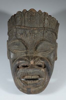 une image représentant un masque en bois dont le visage est sculpté dans le bois