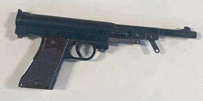 un pistolet jouet posé sur une table, sur fond blanc